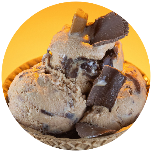 Tempting chocolate ice cream with caramel chunks against an orange background.